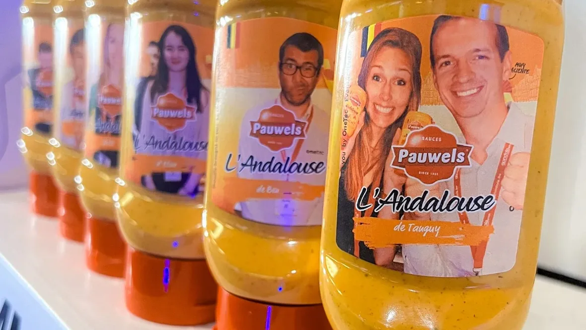 Pauwels Andalouse sauce bottles in a row, each with a different visitor's photo on the label