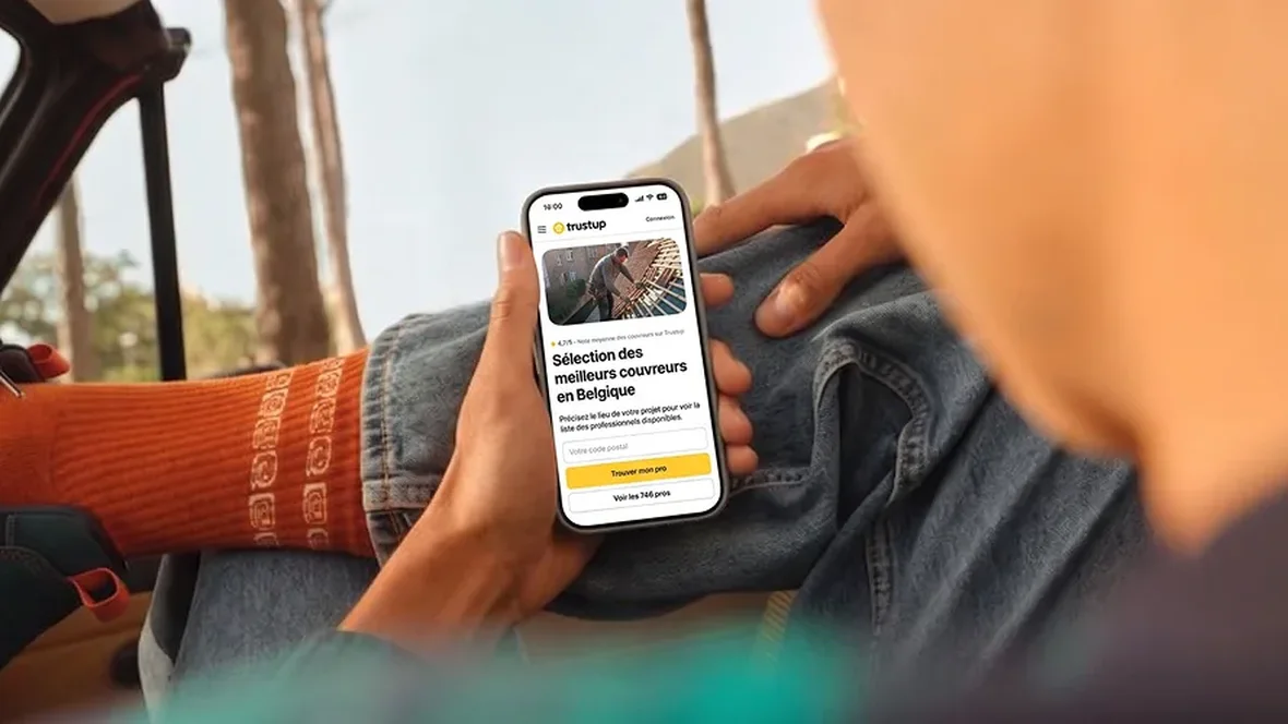 A person holding a phone with the Trustup app open on a list of roofers in Belgium